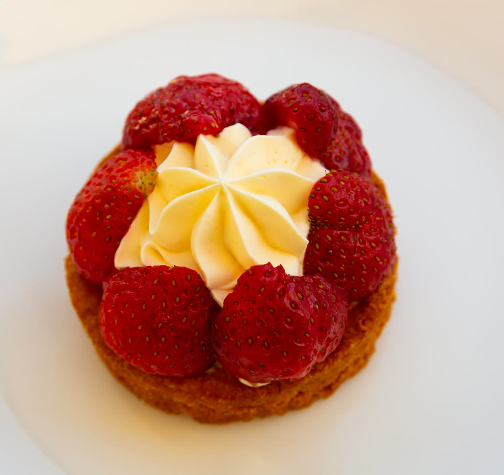 Strawberry dessert with cream on white plate