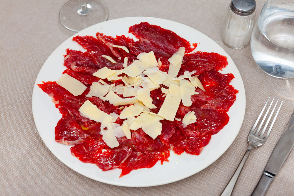 Sliced carpaccio. Raw beef meat on plate