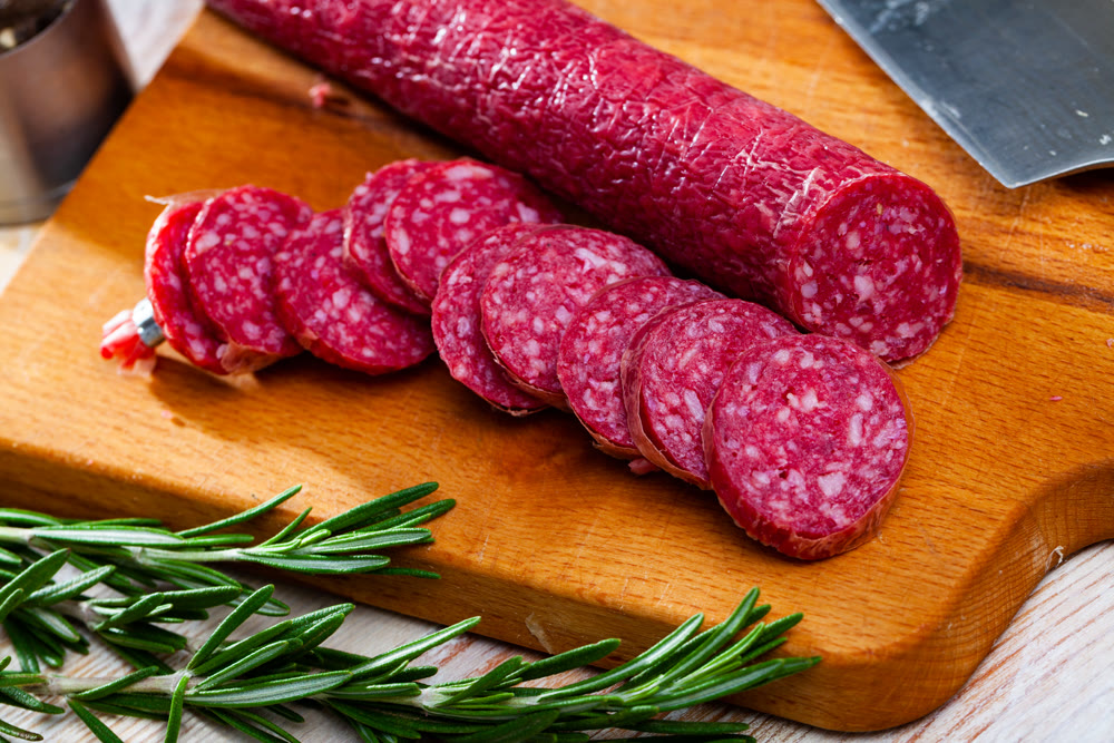 Sliced half-smoked sausages on wooden table. Traditional spanish meat product