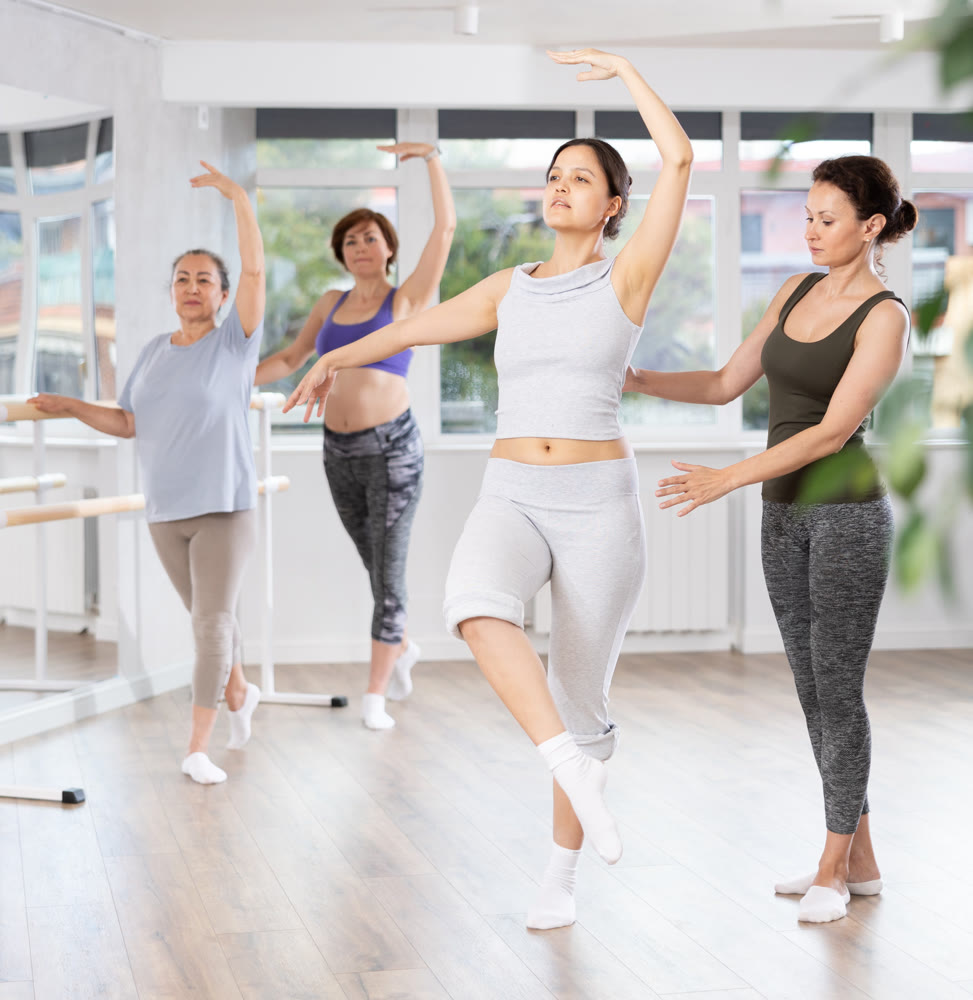 Ballet lesson for amateurs - choreographer teaches women of different ages different ballet steps in studio