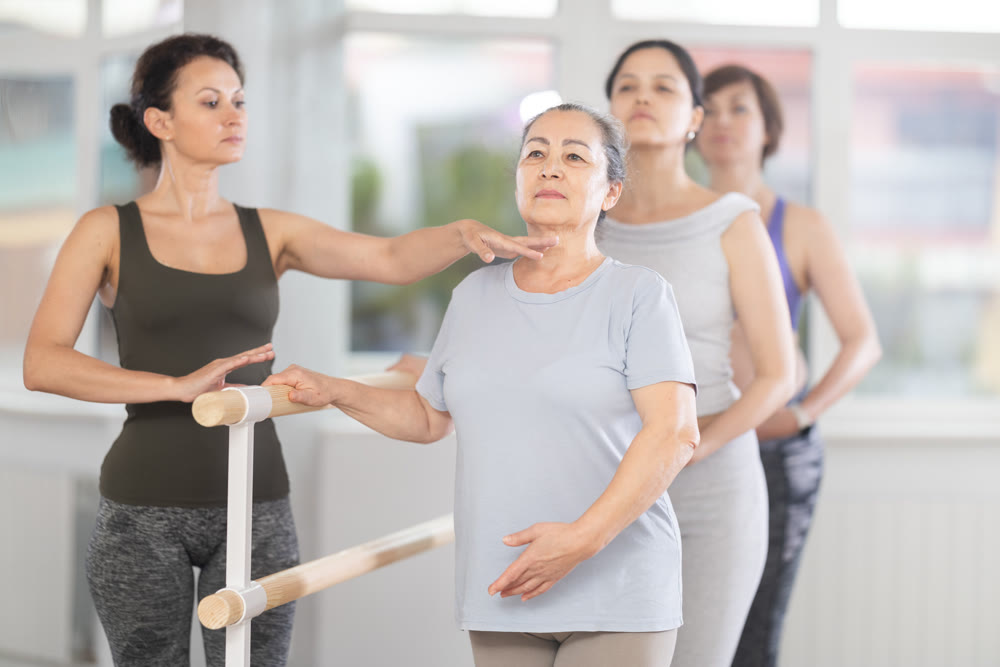 Choreographer coach teaches amateur students to keep their heads straight during ballet lesson