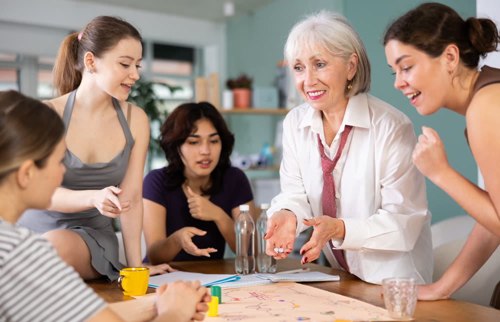 Group of women playing board game around a table